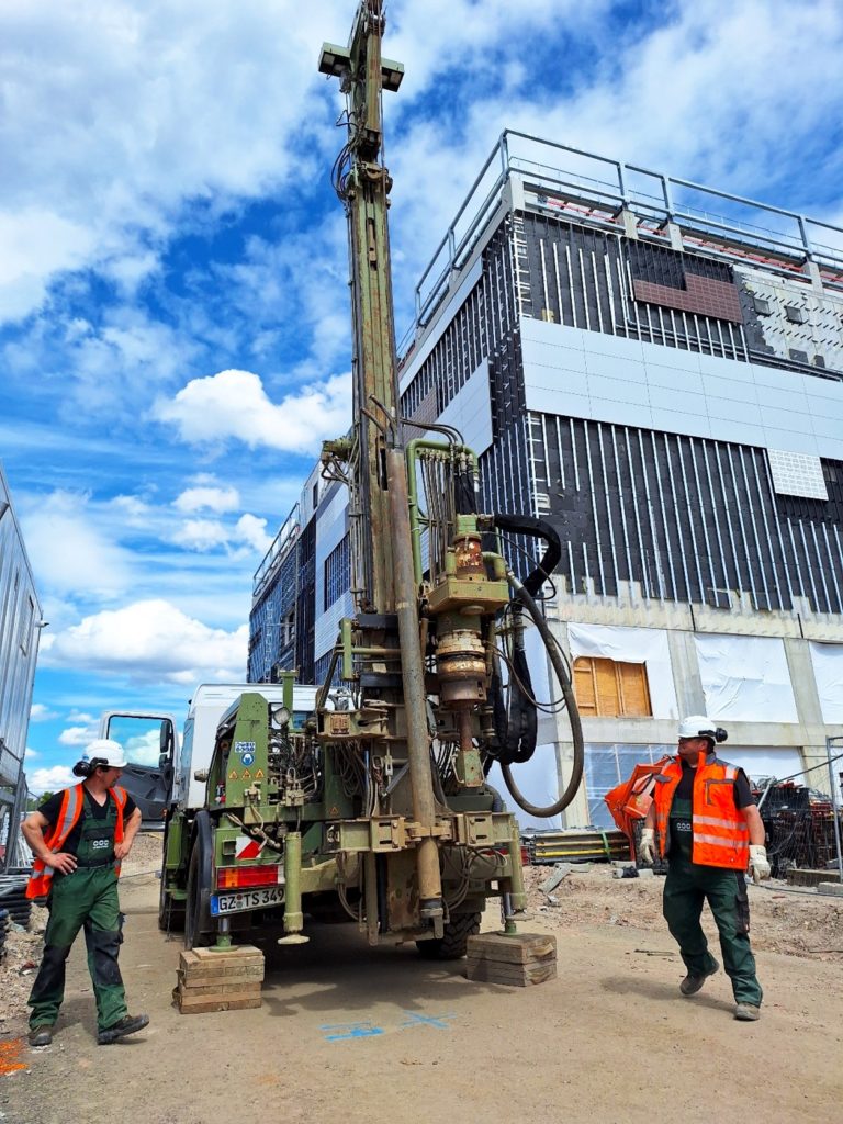 Zwei Terrasond-Mitarbeiter an einem Bohrgerät auf einer innerstädtischen Baustelle